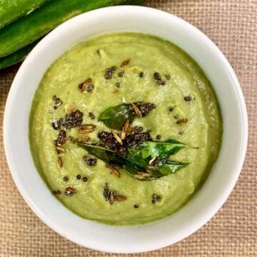 Ridge Gourd Chutney served in a bowl topped with tempering and ridge gourd on the side