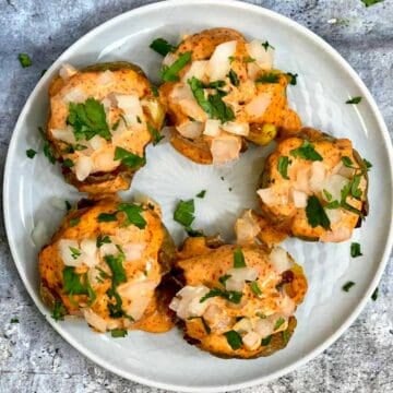 spiced cajun potatoes with mayonnaise dressing on top and garnished with cilantro