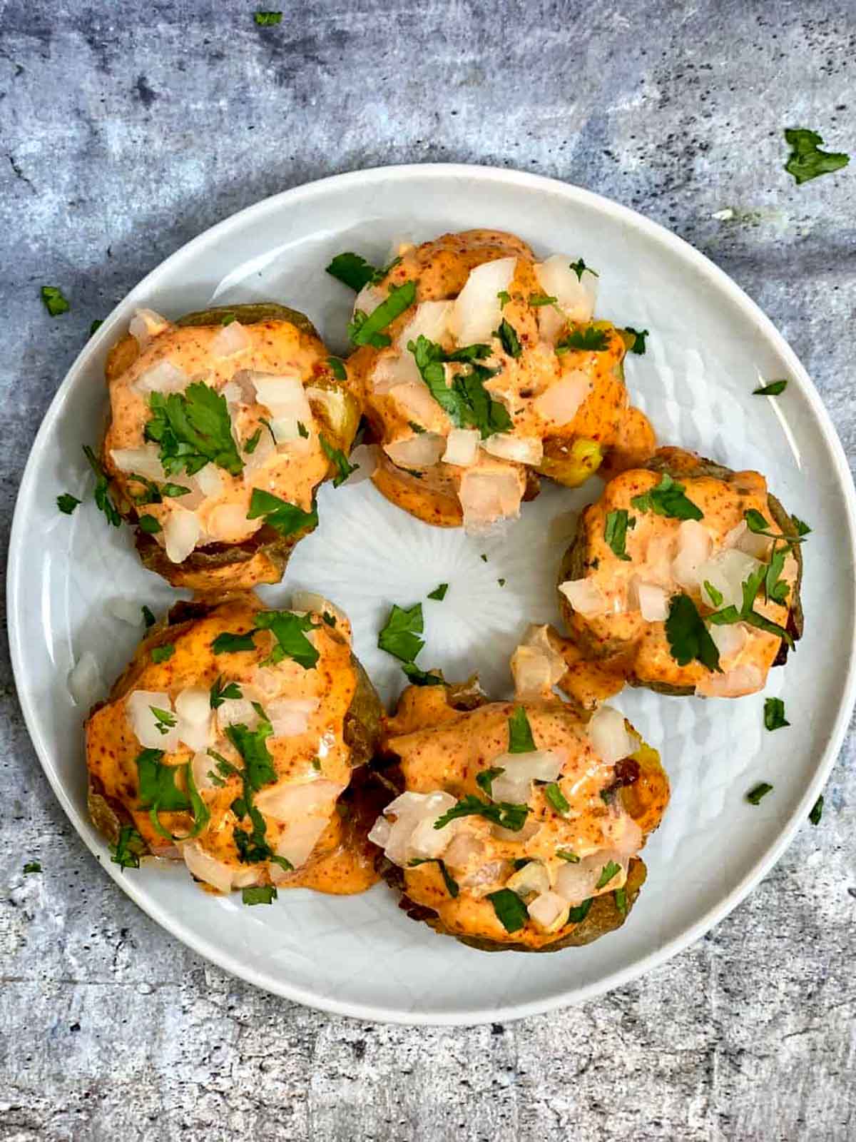 spiced cajun potatoes with mayonnaise dressing on top and garnished with cilantro