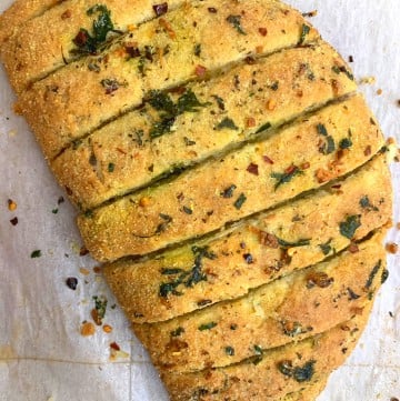 dominos style stuffed garlic bread served on a plate garnished with italian seasoning