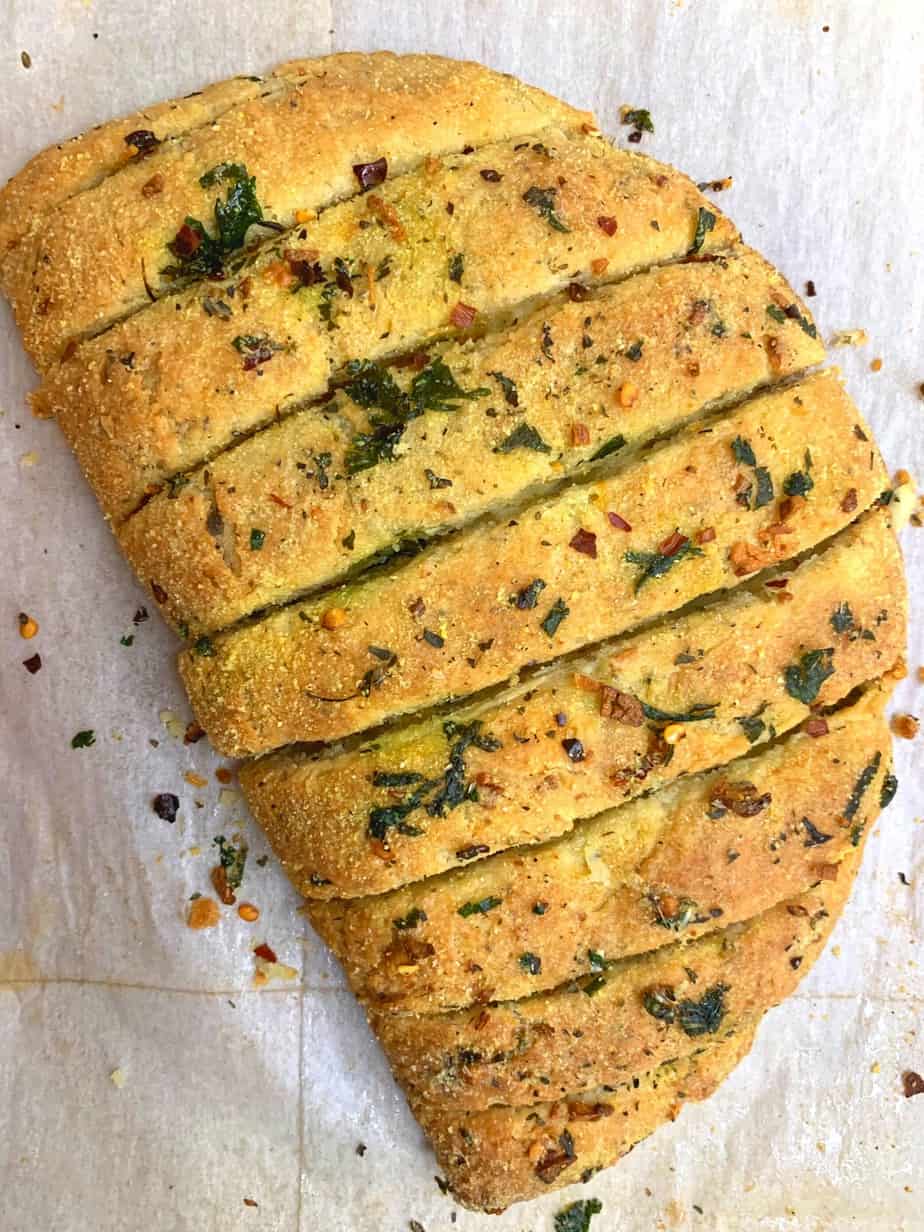 dominos style stuffed garlic bread served on a plate garnished with italian seasoning