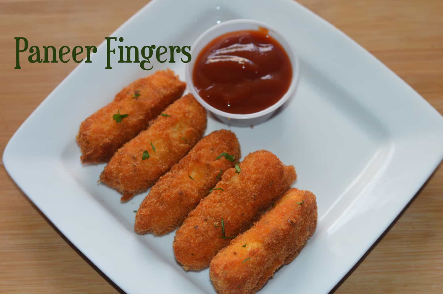 Crispy Paneer Fingers served on a plate with tomato ketchup on the side