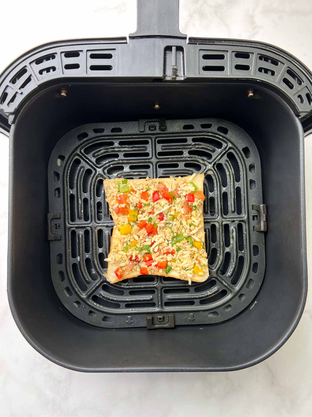 chili cheese toast bread slice on the air fryer basket