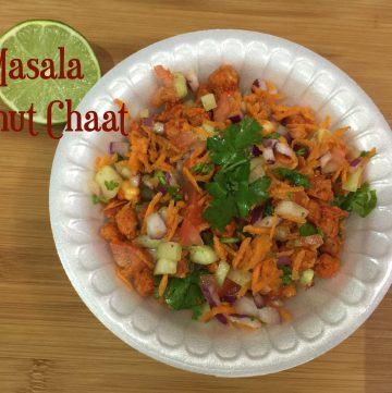 Masala Peanuts Chaat served in a plastic bowl topped with cilantro and lemon on the side