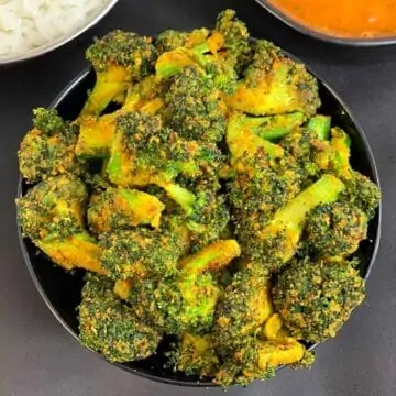 Broccoli Besan Sabji served in a black bowl with rice and rasam on side
