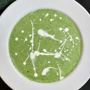 Broccoli Spinach Soup served in a soup bowl with cream on top