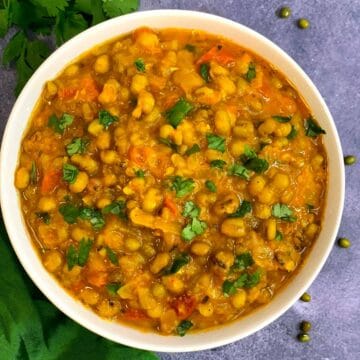 Whole Green Moong Dal served in a white bowl garnished with cilantro