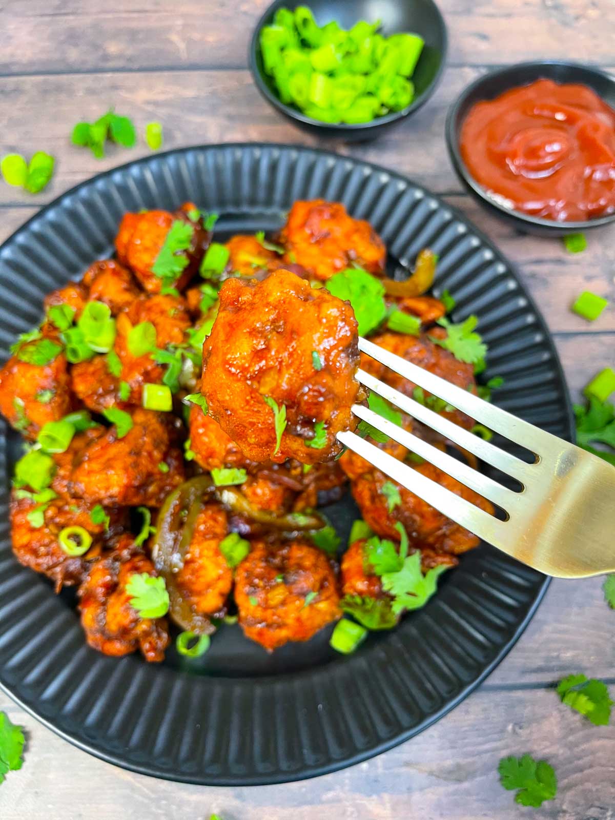 a piece of cauliflower manchurian in a fork 