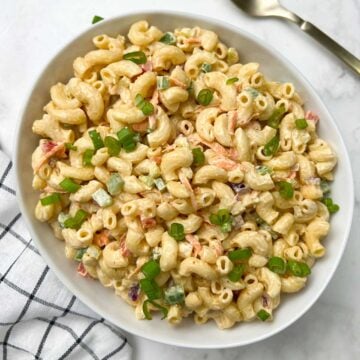 macaroni salad served in a large bowl garnished with spring onions