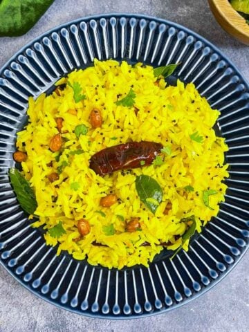 mavinakayi chitranna served in a plate with lemon and cucumber salad on the side