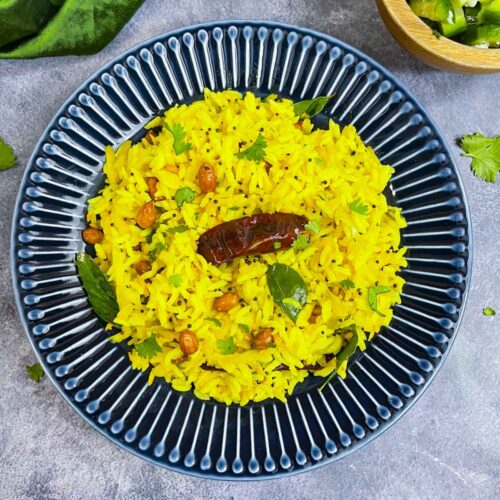 mavinakayi chitranna served in a plate with lemon and cucumber salad on the side