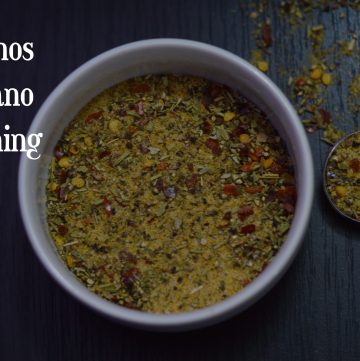 Oregano Seasoning served in a bowl with spoon full of spices on the side