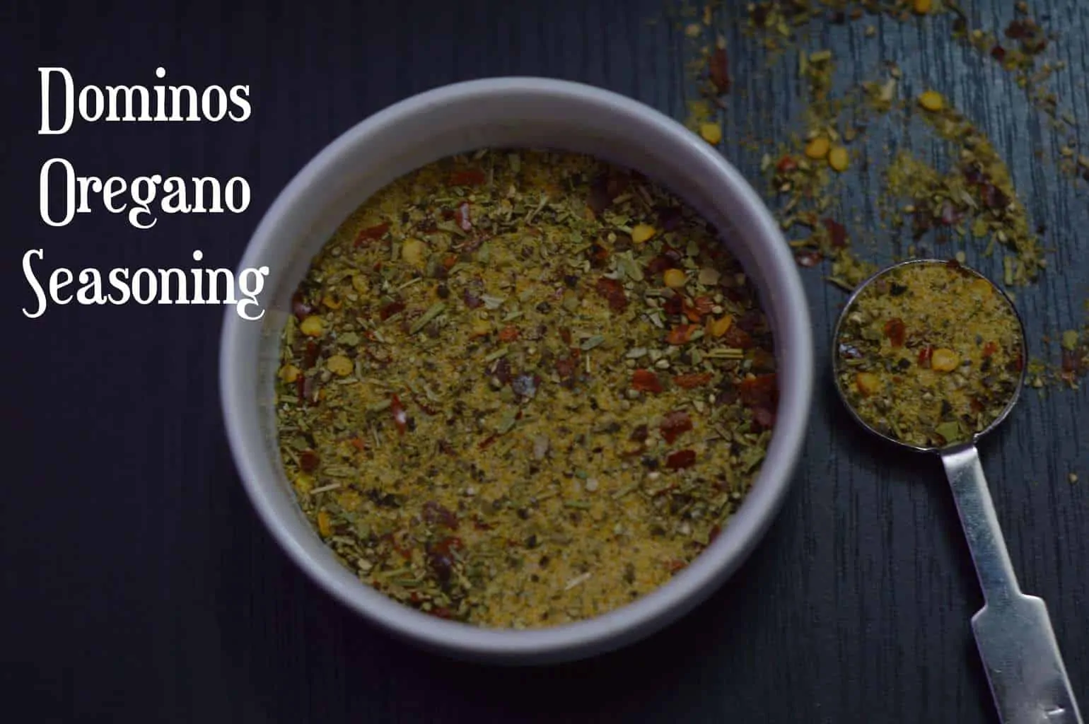 Oregano Seasoning served in a bowl with spoon full of spices on the side
