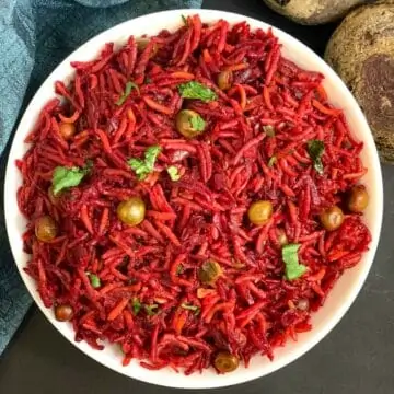 Beetroot Rice served in a bowl garnished with cilantro and whole beetroot on right