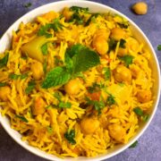 Chole Biryani (chickpea biryani) served in a bowl with cooked chickpeas on side