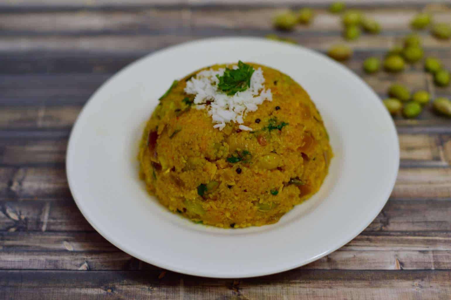 Avarekalu Upma served on a plate garnished with fresh coconut and cilantro