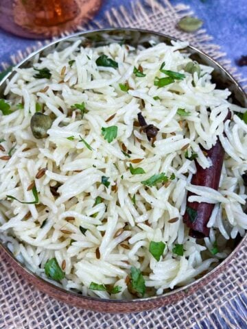 Restaurant style Instant Pot Jeera/cumin rice served in a bowl with cilantro on the side