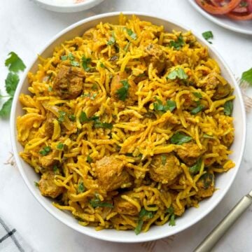 soya chunks biryani (meal maker biryani) served in a bowl with onion salad and raita on the side