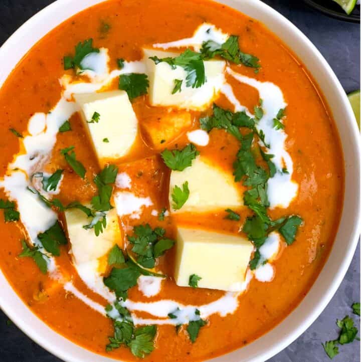 Restaurant Style Paneer Butter Masala served in a bowl garnished with fresh cream and cilantro