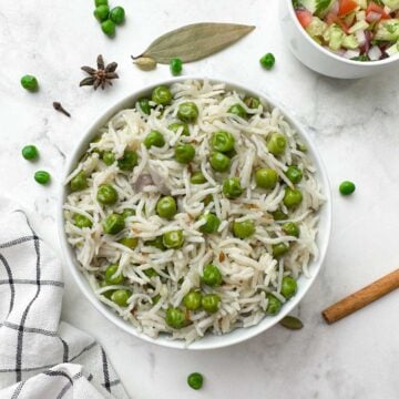 instant pot peas pulao (matar pulao) served in a bowl with salad and spices on the side
