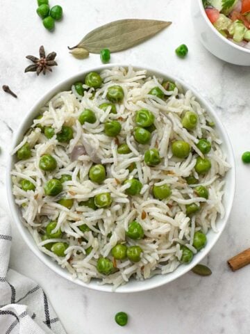 instant pot peas pulao (matar pulao) served in a bowl with salad and spices on the side