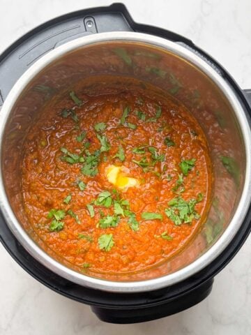 Pressure Cooker Pav Bhaji in the instant pot with a dollop of butter and coriander leaves on the top.