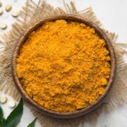 Hurigadale chutney pudi served in a wooden serving bowl with curry leaves kept for decoration.