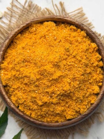 Hurigadale chutney pudi served in a wooden serving bowl with curry leaves kept for decoration.