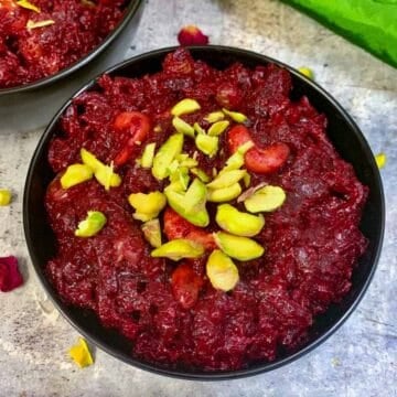 pressure cooker beetroot halwa served in a black bowl garnished with pistachios