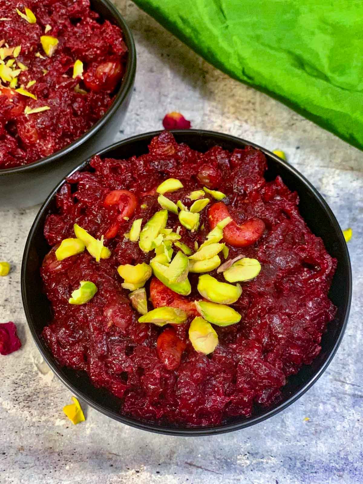 Instant pot beetroot halwa served in a black bowl garnished with pistachios