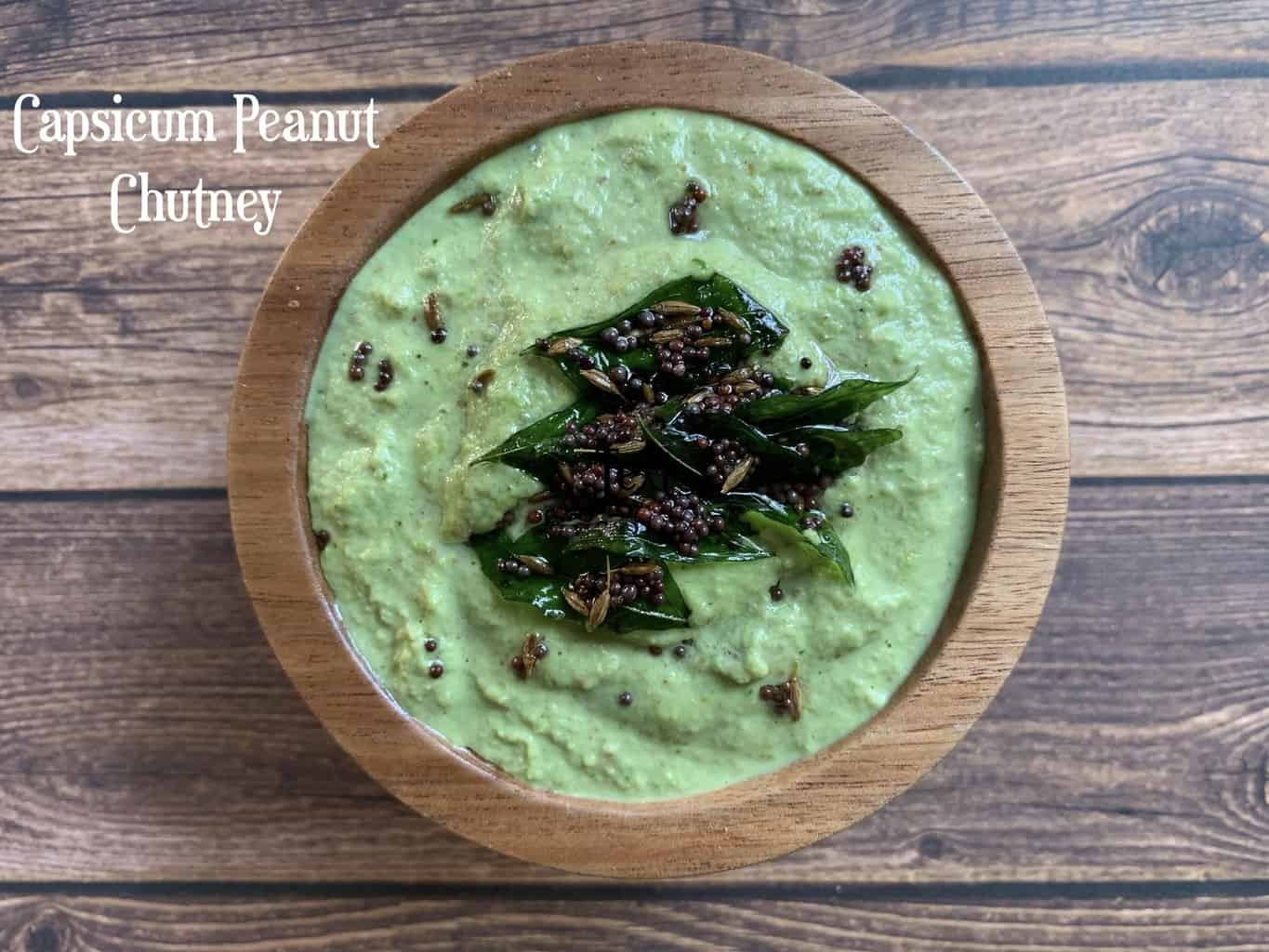 capsicum peanut chutney served in a wooden bowl with tempering on the top