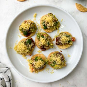 avocado papdi chaat served on a serving plate with chutneys on the side