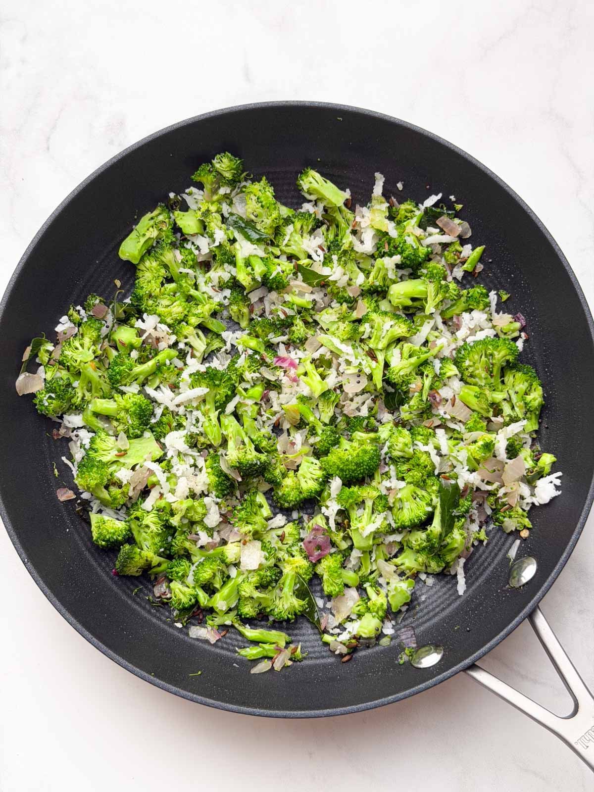 Broccoli poriyal in a black pan