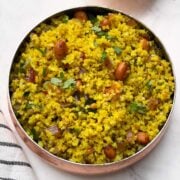 little millet lemon rice served in a copper color bowl and coriander on the side.