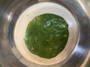 spinach puree and dosa batter in a vessel