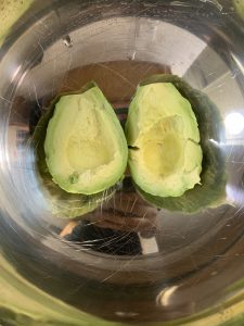 scooped avocado flesh in a bowl to make avocado paratha recipe