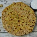 chole paratha served on a plate with curd on the side