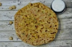 chole paratha served on a plate with curd on the side