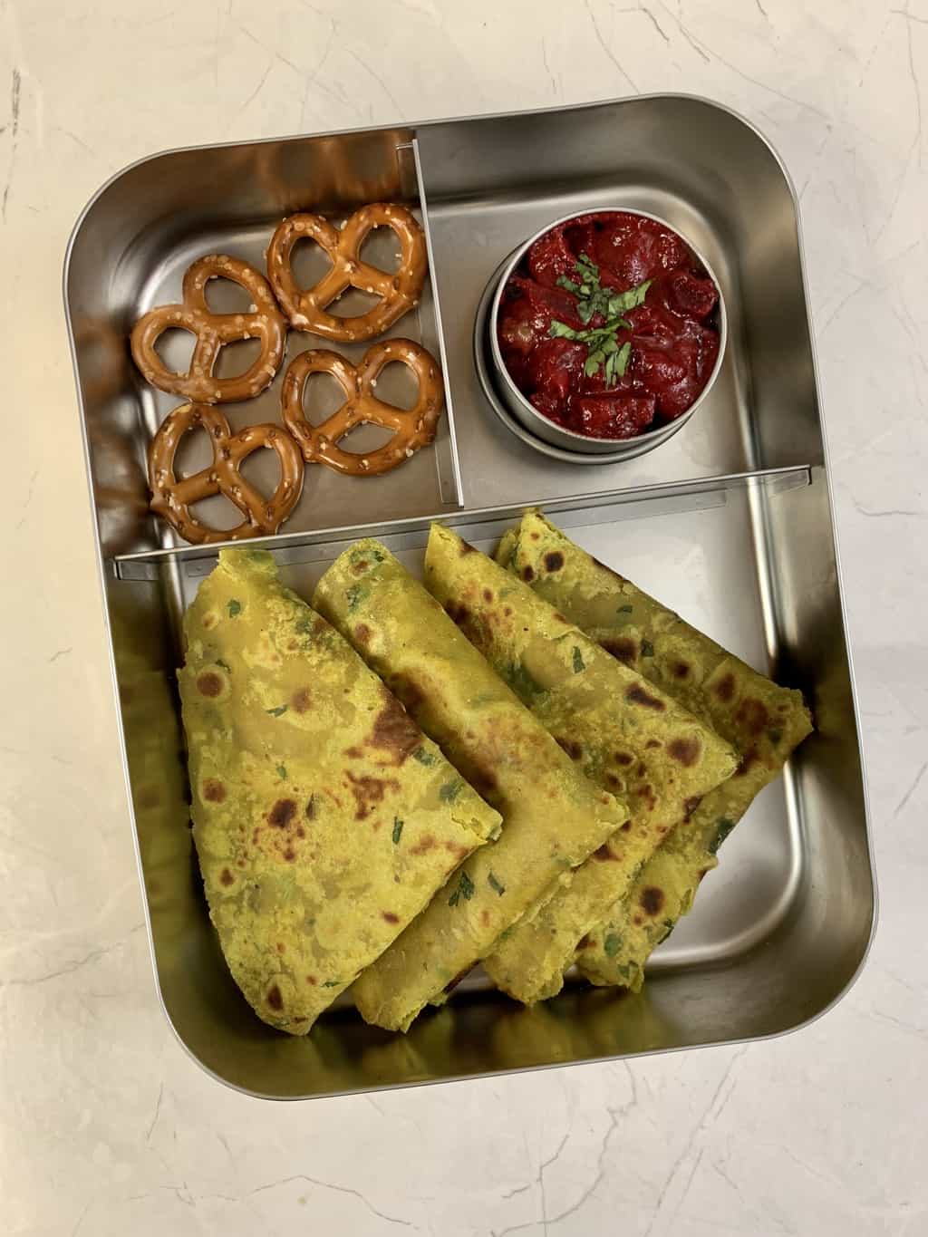 avocado paratha in kids lunch box with pretzels and beetroot curry.