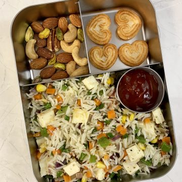 Paneer fried rice with cookies and nuts in steel bento lunch box