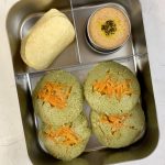 Spinach idli with peanut chutney and chips in bento steel lunch box
