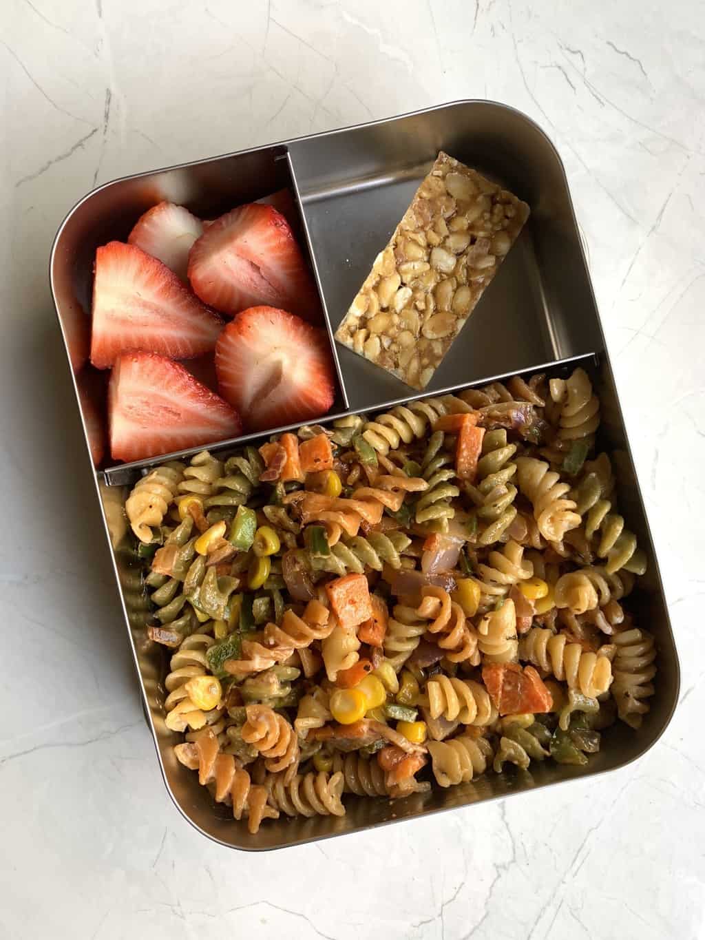 cheesy mayonnaise pasta with chikki and strawberries in bento steel box