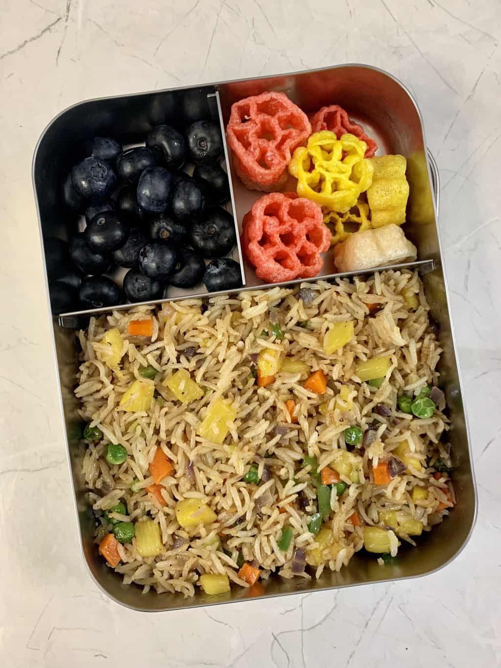 pineapple fried rice, fryums and blueberries in steel lunch box.