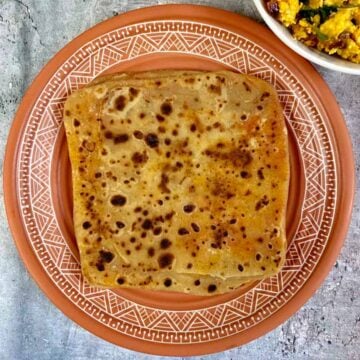 ajwain mirch paratha served on a plate with paneer bhurji on side