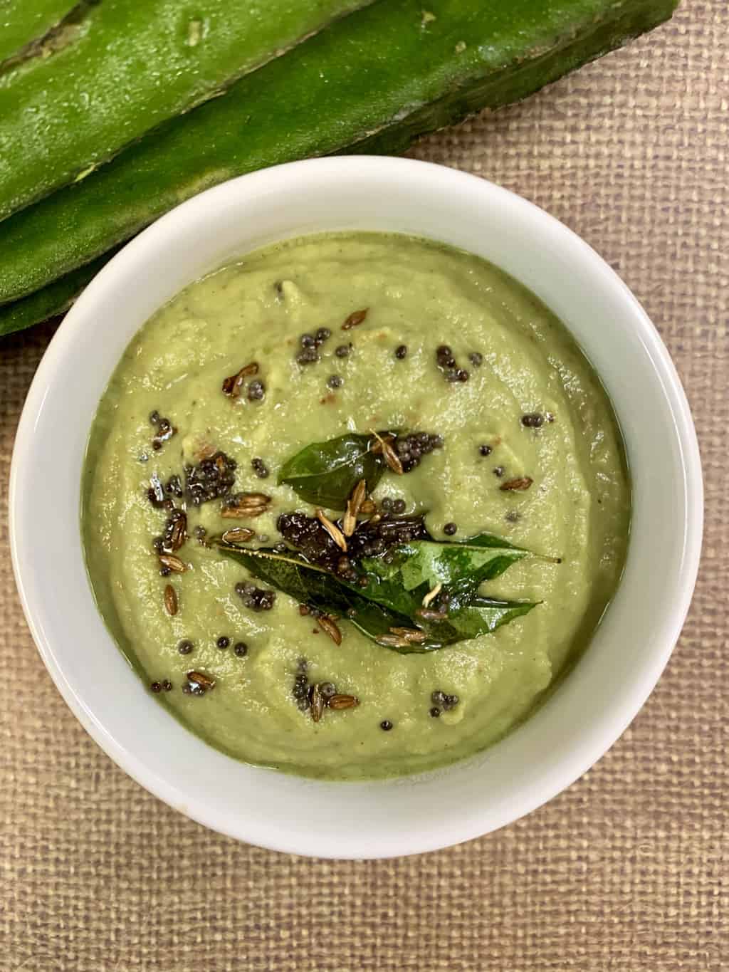 ridge gourd chutney served in a bowl topped with tempering