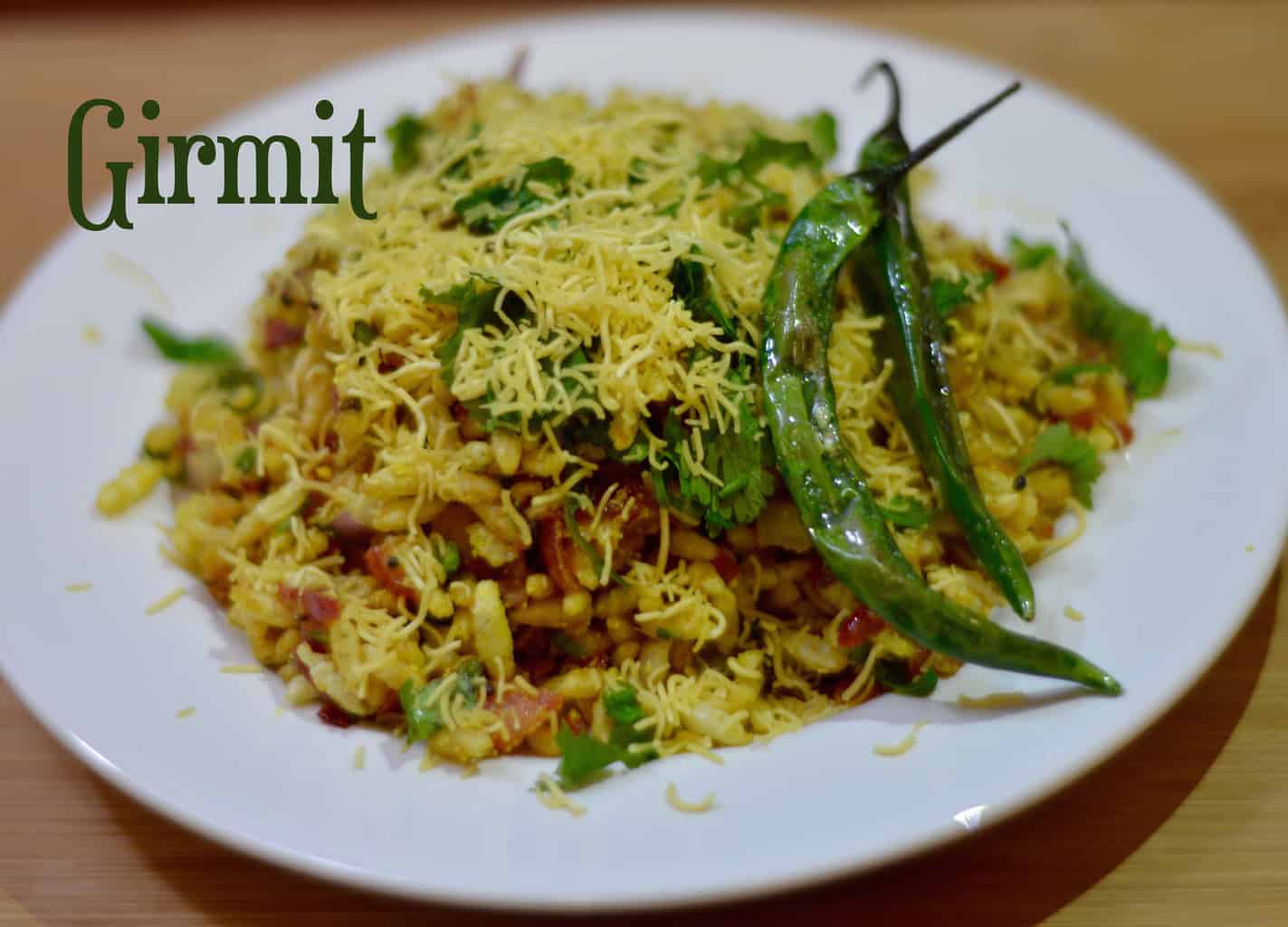 girmit served on a plate with sev and fried chili on top