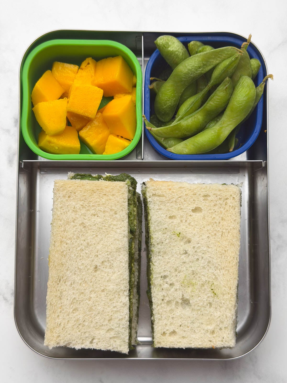 Cucumber Chutney Sandwich,Steamed Edamame and Mango in a steel bento box.
