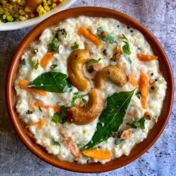curd quinoa served in bowl garnished with roasted cashews