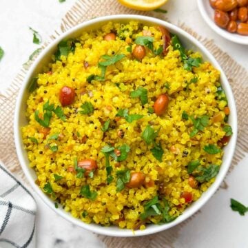 Lemon quinoa served in a bowl with roasted peanuts on the side.