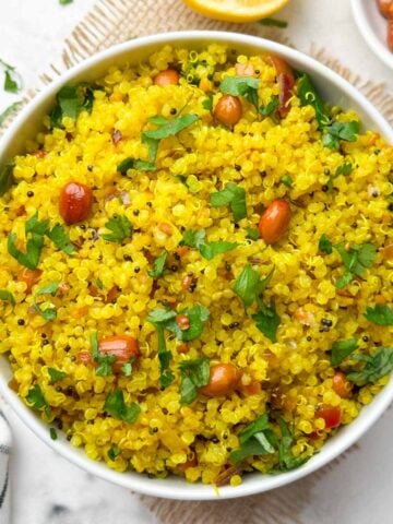 Lemon quinoa served in a bowl with roasted peanuts on the side.